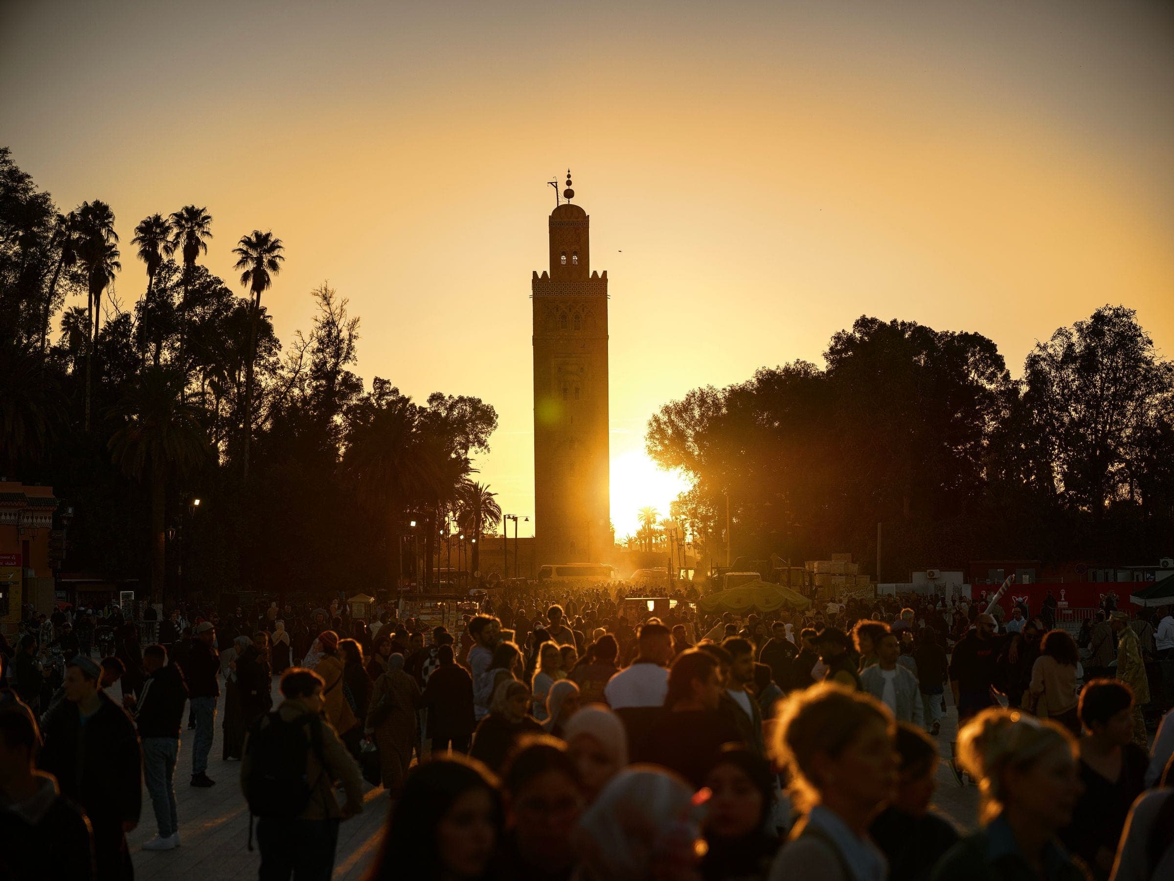 Crowds beneath the Koutoubia Mosque minaret at sunset in Marrakech