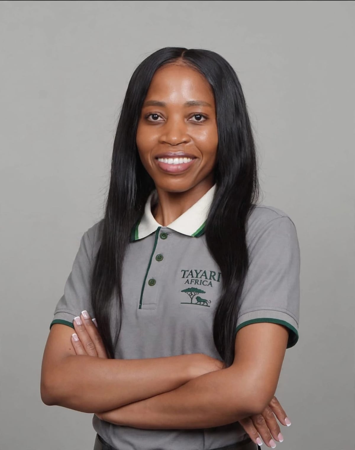 Naomi Misati, smiling, in a grey Tayari Africa polo shirt