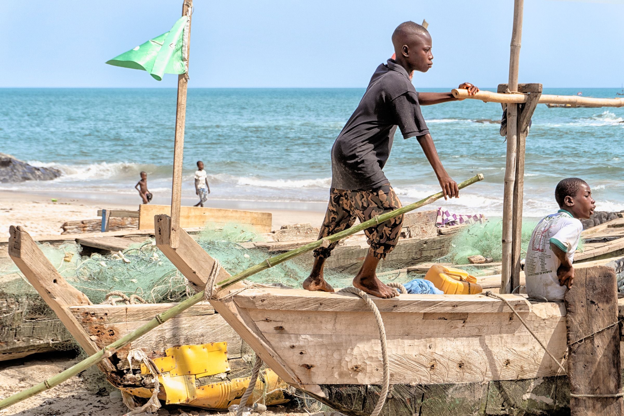 Boys on a wooden fishing boat at Elmina, Ghana