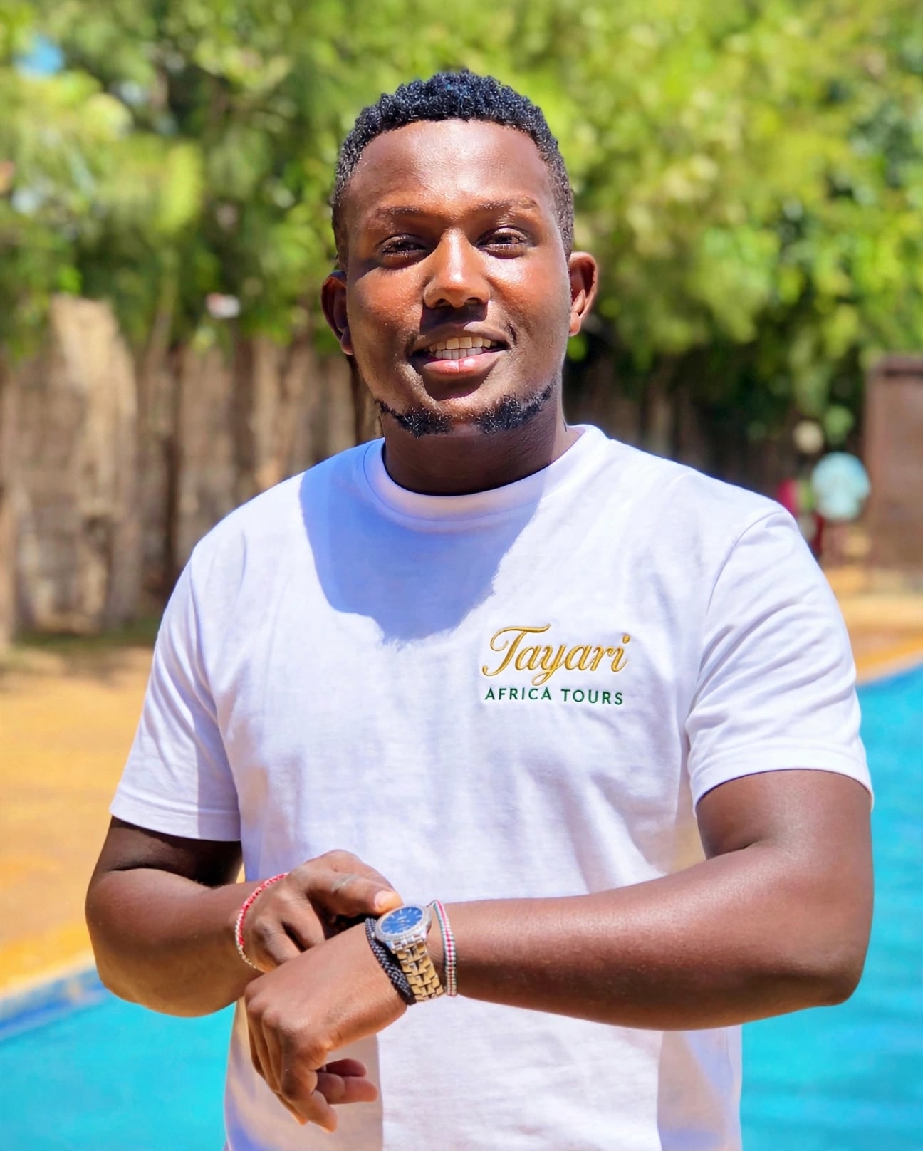 Adam on a white shirt written Tayari Africa Tours for a guide